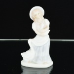 ESCULTURA, uma (1) figurativa feminina, representando mulher e gansos, confeccionada em porcelana policromada em tons pasteis, selo da KS Collection, medindo 12,5 cm altura, vide foto.