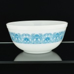 VIDRO, uma (1) tigela opalinada, branca e leitosa, dita milk glass, ornada com esmaltação representando barrado vegetalista em silhuetas estilizadas na tonalidade azul, medindo 22,5 cm diâmetro e 10,5 cm altura, marca PYREX, made in USA, sinais de uso, vide foto.