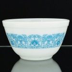 VIDRO, uma (1) tigela opalinada, branca e leitosa, dita milk glass, ornada com esmaltação representando barrado vegetalista em silhuetas estilizadas na tonalidade azul, medindo 14,5 cm diâmetro e 8,5 cm altura, marca PYREX, made in USA, sinais de uso, vide foto.