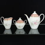 PORCELANA, conjunto para café com três (3) itens: 1 bule; 1 cremeira e 1 açucareiro, ornamentação floral policromada, faixas na tonalidade rosa com arremates em silhuetas vegetalistas a ouro, marca STEATITA (Campo Largo, PR, funcionou de 1954 a 1994), medindo a maior peça 16 cm altura, vide foto.