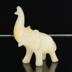 ESCULTURA, uma (1) representando elefante, entalhada em ônix branco, medindo 8,5 cm comprimento, vide foto.