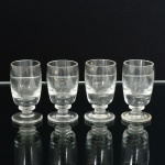 VIDRO, quatro (4) taças de pé baixo para licor, incolores e translúcidas, fuste com disco intermediário, base em bolacha, medindo 7 cm altura, sinais de uso, vide foto.