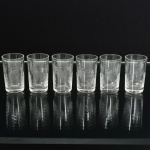 VIDRO, seis (6) copos para licor, incolores e translúcidos, singela lapidação vegetalista, cilíndricos, medindo 3 cm diâmetro e 5 cm altura, sinais de uso, vide foto.