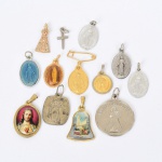 ARTE SACRA, treze (13) medalhas e cruz, variadas, confeccionadas em materiais diversos, vide foto.