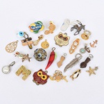 DIVERSOS, um (1) saco com mais de 20 itens, dentre pingentes, partes de bijuterias, pins, broches, etc., alguns no estado, vide foto.
