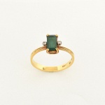 JOIA, um (1) anel confeccionado em OURO, contrastado 750 milésimos, com pedra central na tonalidade verde,lapidação esmeralda e dois diamantes com dois pontos cada um, tamanho do aro 18, peso total 2,5 gr., vide foto.