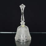 CRISTAL, uma (1) sineta de mão, incolor e translúcida, ornada em elementos vegetalistas, dedão e geométricos,detalhes acetinados, pega hexagonal afinando na parte central, medindo 20 cm altura, sinais de uso, vide foto.