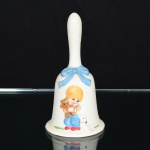 BISCUIT, uma (1) sineta de mão com ornamentação relevada representando criança com cachorro e urso depelúcia, além de laçarote, pintada a mão em policromia, marca JASCO  Taiwan, medindo 13 cm altura, vide foto.