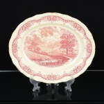 FAIANÇA INGLESA, uma (1) travessa oval, ornada com paisagem, legenda: Noon After Constable, borda combarrado vegetalista, tonalidade magenta, bicado na borda visto pela parte de traz, marca W. H. GRINDLEY & Co(fundada em 1880 por William Harry Grindley em parceria com J & G. Meakin; 1884 terminou a parceria; 1926 morreuGrindley; 1960 Alfred Clough assume a empresa; 1991 fechou a fabrica), medindo 28 x 23,5 cm, sinais de uso, videfoto.