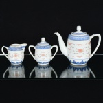 PORCELANA CHINESA, conjunto para café com três (3) itens, ornamentação floral policromada, barradosvegetalistas e geométricos na tonalidade azul, arremates com frisos a ouro, técnica dita grão de arroz (denominação dadaas peças em porcelana que, após minuciosamente entalhadas com estilete, são embebidas diversas vezes em barbotina,antes da queima, para dar este efeito), sendo: 1 bule; 1 cremeira e 1 açucareiro, medindo a maior peça 15,5 cm altura,marca de origem em legenda e caracteres na base, vide foto.
