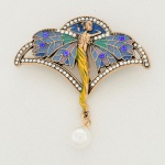 BIJUTERIA, um (1) broche, estilo Art Nouveau, representando mulher alada, confeccionado em metal douradocom cloisonné policromado e apliques em zircônios e imitação de pérola, medindo aproximadamente 6 x 6 cm, videfoto.