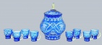 Conjunto com 01 poncheira e 08 canecas, em cristal double azul; pega da tampa da poncheira multifacetada; poncheira e canecas lapidadas com motivos frutais, vegetalistas e caneluras elípticas. Concha ausente. Medidas: 36 x 24 cm (poncheira); 11 x 9 cm (canecas). Abertura na tampa para o cabo da concha com ínfimos bicados.
