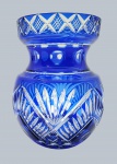 Vaso em cristal double azul cobalto, lapidado com padrões fitomórficos, ovais e detalhes em forma de X; borda circular e corpo abaulado. Medidas: 20 x 16 cm. Dois ínfimos bicados na borda.