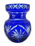 Vaso em cristal double azul cobalto, lapidado com padrões florais e fitomórficos, detalhes ovais e em forma de X; borda circular e corpo abaulado. Medidas: 20 x 16 cm.