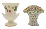 ROSENTHAL BAVARIA / WEDGWOOD MADE IN ENGLAND - 02 bibelôs em porcelana, sendo: um no formato de um cesto com coloridos ramos de flores, da manufatura alemã Rosenthal; e o outro no formato de taça, decorada com coloridos padrões frutais, vegetalistas, florais e filetes dourados, da manufatura inglesa Wedgwood. Medidas: 10 x 8 cm; 9 x 9 cm. Alça do cesto ausente (com danos).
