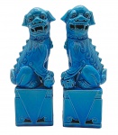FOO DOGS - Casal de cães-foo, também conhecidos como Leões Guardiões Chineses, cada um sentado sobre base retangular com detalhes triangulares e de volutas vazadas. Tradicionalmente são colocados nas entradas de templos, palácios e residências para afastar os maus espíritos. O macho, com a esfera, simboliza a proteção da estrutura física, e a fêmea, com o filhote, protege as pessoas e a harmonia familiar. Em cerâmica vitrificada na cor azul turquesa. Medidas: 25 x 10 x 7 cm. Escultura do macho com sinais de restauro na região do pescoço e cabeça, e ínfimo bicado na parte posterior.