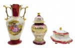 CERÂMICA SÃO JOSÉ PEDREIRA - 03 itens em porcelana, sendo: 01 potiche decorado com elementos vegetalistas e filetes em dourado; 01 vaso com alças laterais douradas e colorida cena galante em sua galeria central; e 01 potiche de formato hexagonal adornado com motivos florais e filetes dourados; itens com detalhes na cor vinho. Potiche maior fabricado pela manufatura brasileira São José Pedreira; vaso e potiche menor sem marca de manufatura. Medidas: 21 x 13 cm; 17 x 9 cm; 9 x 12 cm.