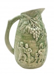 LUSOBRASIL - Jarra em cerâmica esmaltada na cor verde, decorado em relevo com parreiral e colhedores de uvas com trajes tradicionais portugueses e em confraternização. Numerada no fundo. Medidas: 23 x 20 cm. Com um ínfimo bicado na borda e no corpo.