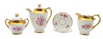 PORCELANA MAUÁ - Parte de serviço de café com 05 itens, sendo: 01 bule, 01 leiteira, 01 açucareiro e 02 pires para xícaras de café, decorados com coloridos motivos florais e douração nas pegas das tampas, bordas e alças. Medidas: 17 x 16 cm; 11 cm (diâm.). Ínfimo bicado na borda do bule; douração infimamente desvanecida em alguns pontos.