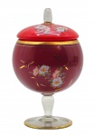 Bomboniere vintage em formato de taça; tampa e corpo em vidro vermelho decorados com coloridos motivos florais e detalhes em dourado; base em vidro translúcido adornada com filetes circulares dourados. Medidas: 29 x 18 cm. Detalhes dourados da tampa desvanecidos em alguns pontos.