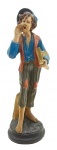 Escultura representando um menino jornaleiro em trajes de época; em gesso policromado. Medidas: 70 x 22 cm. Com ínfimos bicados. Recomendamos o envio por transportadora dada a fragilidade da peça.