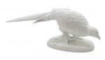 VISTA ALEGRE PORTUGAL - Escultura com a representação de um faisão ao lado de um galho de árvore; em biscuit; fabricada pela tradicional manufatura portuguesa Vista Alegre, fundada em 1824. Medidas: 37 x 13 cm. Uma das folhas do galho com sinais de restauro; uma das folhas com fio de cabelo.