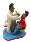 MESTRE EZEQUIEL - ARTE POPULAR - Grupo escultórico com a representação, em tom humorístico, de um dentista tratando o seu paciente; obra no estilo do Mestre Vitalino (1909-1963), cujas esculturas eram inspiradas na cultura, folclore e tradição do povo nordestino. Em barro cozido policromado; assinado na base. Medidas:17 x 13 x 11 cm. Ínfimo bicado na base.