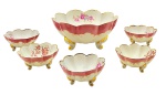 Conjunto com 01 bowl e 05 tigelas para sobremesa, com bordas onduladas decoradas com filetes dourados, adornados internamente com coloridos motivos florais e externamente com faixa rosa e volutas; base trípode com douração. Em porcelana. Medidas: 22 x 10 cm; 11 x 5 cm.