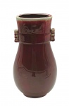 Vaso no formato ovalado, com pegas laterais cilíndricas, adornado nas cores vinho e cinza; em cerâmica esmaltada. Medidas: 30 x 17 cm.
