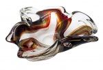 MURANO - Centro de mesa no formato orgânico, em vidro translúcido decorado com faixas fluidas nas cores ocre, marrom e preta. Medidas: 23 x 21 x 7 cm.
