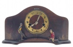 Raro e antigo relógio de mesa com autômato "Futebol", a duas cordas. Caixa em madeira nobre com topo em forma de arco, apresentando em sua parte frontal um mecanismo de autômato integrado com temática esportiva, com dois jogadores de futebol em madeira e policromados, um à esquerda em posição de chute, cuja perna esquerda se movimenta ao bater das horas, e um à direita em posição de defesa. É possível que originalmente houvesse uma bola, ausente atualmente, que era chutada. Mostrador em algarismos indo-arábicos; base com detalhes boleados. Chave inclusa. Medidas: 27 x 15 x 8 cm. Não testado; mostrador e caixa com desgastes; vidro frontal do mostrador ausente; pintura policromada com desgastes em ambos jogadores de futebol.