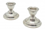 Par de castiçais em prata, peso total: 130 g; com recheio de outros materiais. Medidas: 7 x 6 cm. Com ínfimos amassados.