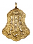 Pingente oriental em prata banhada a ouro, peso: 15 g; adornado com padrões fitomórficos, dragões e caracteres chineses. Medidas: 7 x 5 cm.