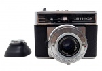 ZEISS IKON - CONTESSAMAT SBE - Antiga câmera analógica alemã produzida na década de 1960. Possui lente de alta qualidade, a renomada Carl Zeiss Tessar de 50mm com abertura máxima de f/2.8, conhecida por excelente nitidez. Foco ajustado sobrepondo duas imagens sobre o visor interno, tipo rangefinder. Acompanha um filtro na cor verde. Não testada. Possui ínfimos desgastes.
