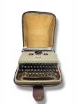 DIVERSOS, uma (1) máquina de escrever portátil da marca OLIVETTI, modelo Lettera 22, em metal na cor bege, teclado com caracteres em português, acompanha maleta original de transporte em material sintético marrom com marcas do tempo e desgastes, medindo 8,5x27x33cm.