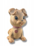 COLECIONISMO, um (1) brinquedo vintage representando cachorro em material emborrachado/vinil, na cor bege, com olhos grandes em plástico preto, coleira rosa com medalha numerada 178, medindo 20,5cm de altura.