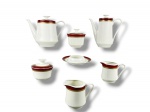 PORCELANA SCHMIDT IVORY CHINA, serviço para chá/café com sete (7) peças confeccionadas em porcelana na tonalidade branca, decorada por espessa faixa na tonalidade marrom e faixa em ouro com decoração geométrica, sendo: A) 1 bule para café, medindo 18x18,5x7,5cm, B) 1 bule para chá, medindo 17x22x9,5cm, C) 1 leiteira, medindo 10,5x13x8cm, D) 1 cremeira, medindo 9x11,5x7cm, E) 1 açucareiro grande, medindo 10x10,5cm, F) 1 açucareiro pequeno, medindo 9,5x10,5cm e G) 1 manteigueira, medindo 3x15cm, sem tampa e bicada na borda. Apresentam leves falhas na douração.
