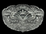 CRISTAL, uma (1) fruteira confeccionada em cristal translucido com rica lapidação de palmas, estrelas, elementos geométricos e caneluras em baixo relevo com borda dentada, apoiada sobre 4 pés afilados, medindo 10x24cm.