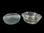 VIDROS, lote com dois (2) pirex confeccionados em vidro translucido, sendo 1 da manufatura CRISTAL, liso, com alças laterais, medindo 9x32x17,5cm bicado na borda e 1 da manufatura MARINEX moldado em caneluras, medindo 6x26cm.