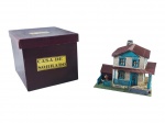 FERROMODELISMO, uma (1) casa sobrado cenográfica para ferrorama, confeccionada em metal e madeira, com dois pavimentos, telhado vermelho, janelas e portas em azul, varanda lateral, cerca frontal e base decorada. Acompanha caixa original identificada Casa de Sobrado. Peça para composição de cenário ferroviário em miniatura, apresentando sinais de uso, medindo 11x13x14cm.