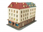 FERROMODELISMO, uma (1) edificação em miniatura para maquete ferroviária, representando prédio urbano com farmácia no térreo, manufatura POLA. Peça em material plástico, com telhados em tons vermelho e verde, múltiplas janelas, portas e base simulando calçada. Apresenta sinais de uso e perda no acessório superior, em bom estado de conservação, medindo 12x18x9,5cm.