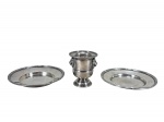 METAL PRATEADO, lote com três (3) peças confeccionadas em metal espessurado a prata, sendo: A) SHEFFIELD, um (1) paliteiro cinzelado por cabeças de leão, borda em gomos torcidos e base circular torneada, ausência das argolas laterais, medindo 7,5x6,5cm e B) WOLFF, 2 porta garrafas com borda cinzelada em caneluras e fitas cruzadas, medindo 13cm de diâmetro.