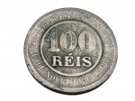 NUMISMÁTICA, uma (1) moeda brasileira de 100 réis, República dos Estados Unidos do Brasil, em metal prateado, com valor ao centro no anverso e estrelas no reverso. Peça apresenta marcas de circulação, desgastes no relevo, medindo 2,5cm de diâmetro.