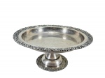 METAL PRATEADO, uma (1) fruteira de pé confeccionada em metal espessurado a prata, bordas ricamentes cinzeladas por elementos vegetalistas com recortes na borda, base circular com haste cônica, apresentando falhas na prateação, medindo 15x33cm.
