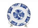 PORCELANA GERMER, um (1) prato decorativo confeccionado em porcelana na tonalidade branca, decorado por paisagens e elementos florais na tonalidade azul, medindo 20,5cm de diâmetro.