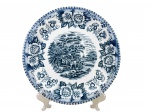 PORCELANA SCHMIDT, um (1) prato decorativo confeccionada em porcelana na tonalidade branca, decorada por cena de carruagem e elementos florais na tonalidade azul, medindo 25,5cm.