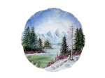 PORCELANA, um (1) prato decorativo confeccionado em porcelana na tonalidade branca com pintura de paisagem com montanhas em policromia e recortes na borda, assinado, vide foto, medindo 27cm de diâmetro.