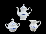 PORCELANA REAL, três (3) peças confeccionadas em porcelana na tonalidade branca, decorada por flores e folhagens em monocromia na tonalidade azul com filetes em ouro, sendo: A) 1 bule para café, bicado na tampa e na alça, medindo 18cm de altura, B) 1 açucareiro, medindo 10x12,5x7,5cm e C) 1 leiteira, medindo 9,5x10,5x6cm.