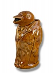 FAIANÇA COLONIAL, uma (1) leiteira representando pinguim confeccionada em faiança argentina na tonalidade marrom, medindo 22,5cm de altura. Sinais de craquele.