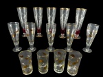 VIDROS, lote com quatorze (14) peças confeccionadas em vidro translucido, sendo: A) 5 tulipas para chopp com lapidação de folhagens e esferas em baixo relevo e parte inferior na tonalidade vinho, apoiada sobre base circular com filetes em ouro, medindo 22x17cm e B) 5 tulipas para chopp com decoração de elementos florais filetados em ouro com falhas na douração, medindo 20x7cm e C) 4 copos para água com decoração de elementos vegetalistas e filetes em ouro, medindo 14x7cm. leves falhas na douração.